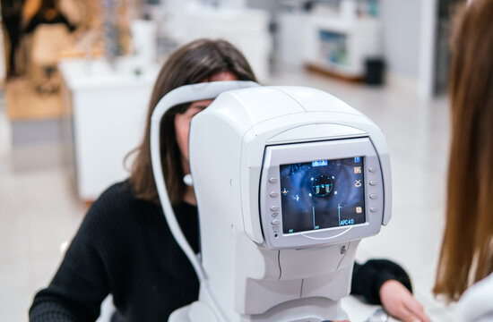 Woman undergo eye examination with optical diagnostic device
