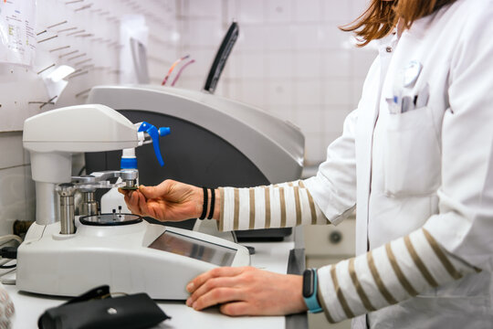 Female optician adjust lens on ophthalmic measurement device