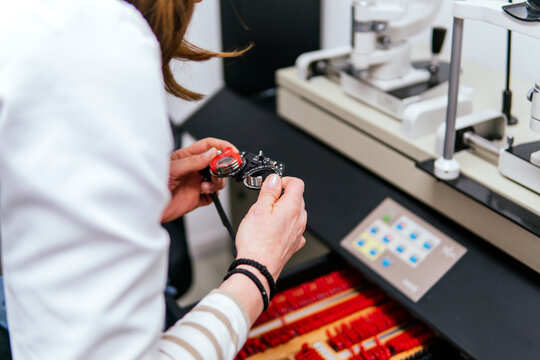 Woman adjusting trial frame during eye examination
