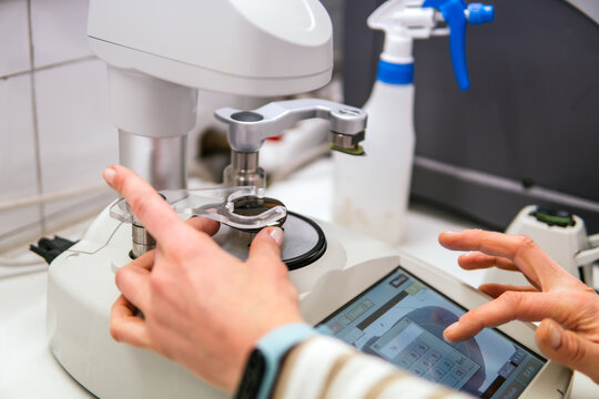 Woman operate optical lens measurement equipment in laboratory