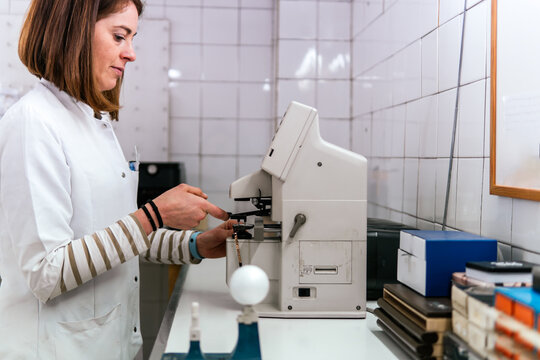 Woman examine sample with laboratory optic microscope