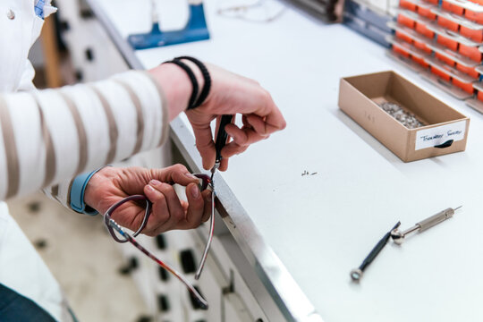 Woman repair eyeglass frame at optical workshop
