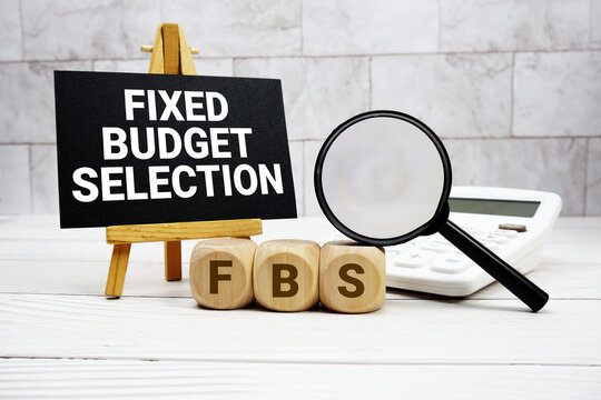 FBS Fixed Budget Selection text with calculator magnifying glass and on wooden background