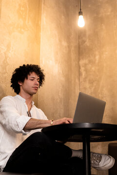 Young man use laptop in urban cafe interior