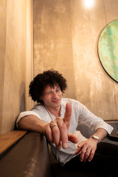 Playful man point finger at camera in city cafe