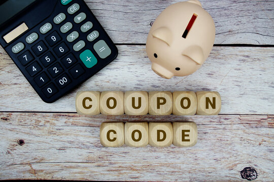 Coupon Code alphabet letters with calculator and piggy bank on wooden background