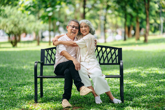 Senior couple embracing park bench love happiness togetherness o