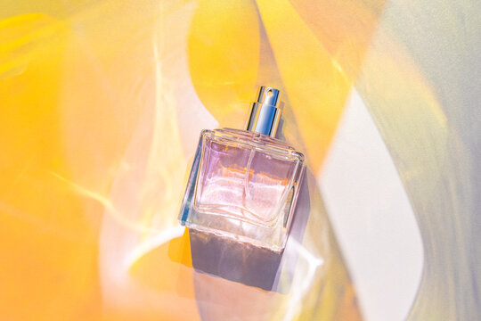 Transparent perfume bottle mockup with bright yellow background