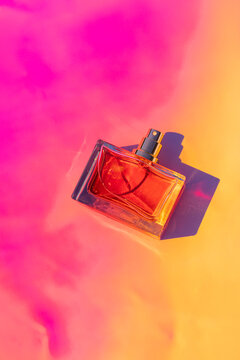 Blank perfume bottle mockup on vibrant pink and yellow background