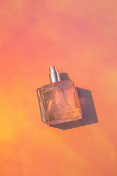 Blank perfume bottle mockup on bright coral background
