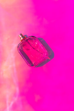 Pink perfume bottle mockup on vibrant abstract background