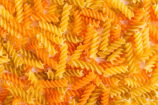 Colorful uncooked fusilli pasta background texture