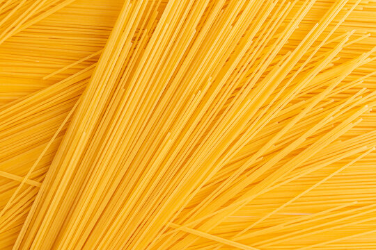 Close-up background of dry spaghetti strands in a pile