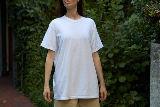 Woman wearing a plain white t-shirt and beige shorts outdoors