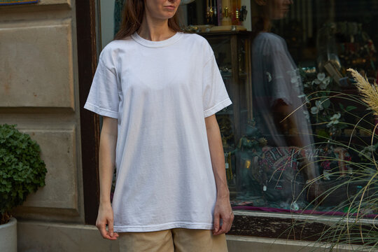Woman wearing a plain white t-shirt and beige shorts outdoors