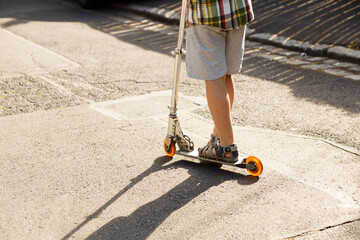Child riding kick scooter on sunny street © Iryna Miadzvedzeva