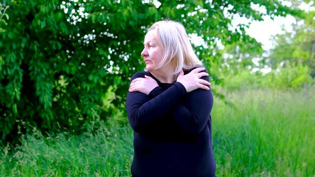 Trying to stay warm woman crosses arms rubs her shoulders against the chill. scene illustrates feeling cold temperature sensitivity seasonal weather discomfort or possible health related weakness.