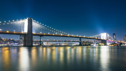 Fototapeta premium Brooklyn Bridge and Manhattan Bridge at Blue Hour with Reflections over the East River, New York City, USA
