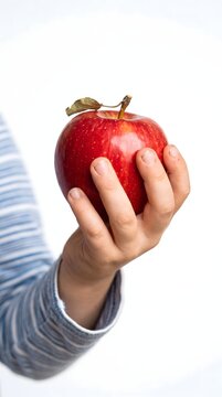 Child holding a fresh ripe red apple in hand close-up with nutrition vitamins agriculture delicious lifestyle snacking isolated