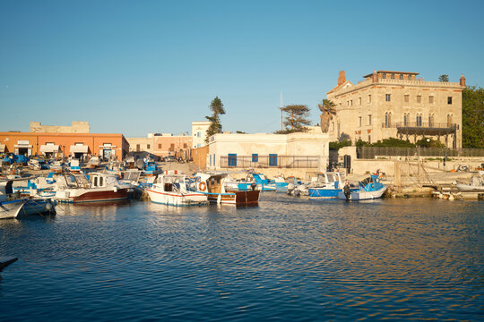 Favignana harbor with fishing boat and historic waterfront tower