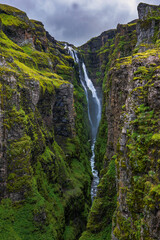 Majestic Waterfall in Moss Covered Canyon Iceland © Earthly Shots
