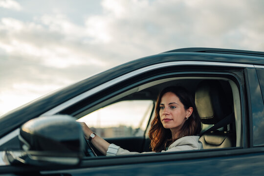 Woman driving car at sunset, enjoying freedom and independence during road trip or daily commute