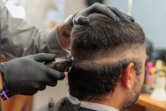 Barber Giving Men's Haircut With Electric Clippers in Barbershop - Close-Up of Fade Haircut