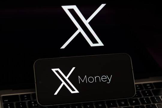 X Money branding displayed on a smartphone with an X logo on a monitor and laptop keyboard in the background. Stafford, United Kingdom, August 2, 2026.