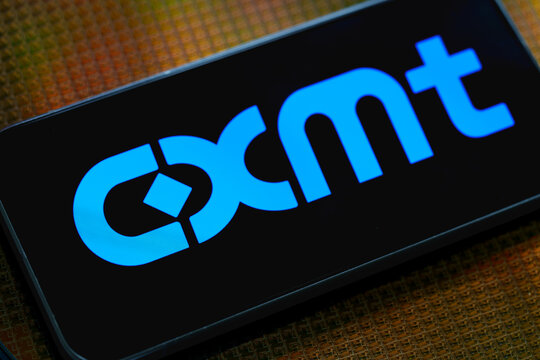 CXMT logo displayed in blue on a smartphone placed on semiconductor wafer with chips in an editorial illustration of the Chinese memory chip manufacturer. Stafford, United Kingdom, August 2, 2026.
