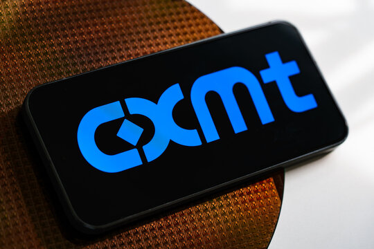 CXMT logo displayed on a smartphone resting on semiconductor wafer with chips in an illustration of the Chinese memory chip manufacturer. Stafford, United Kingdom, August 2, 2026.