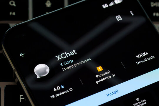 XChat app listing by X Corp displayed in Google Play Store on a smartphone resting on a laptop keyboard. Stafford, United Kingdom, August 2, 2026.
