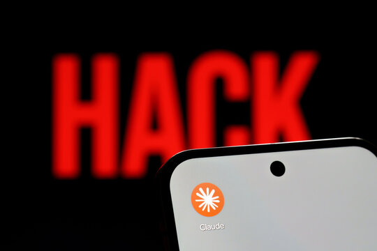 Claude app logo displayed on a smartphone against a red HACK warning in an AI security illustration. Stafford, United Kingdom, August 2, 2026.