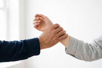 Fototapeta premium Hand firmly grasping the wrist of another person nearby