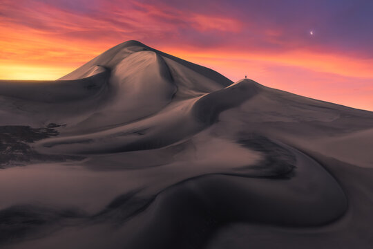 Lone traveler atop Saujil Dunes at sunset, Catamarca