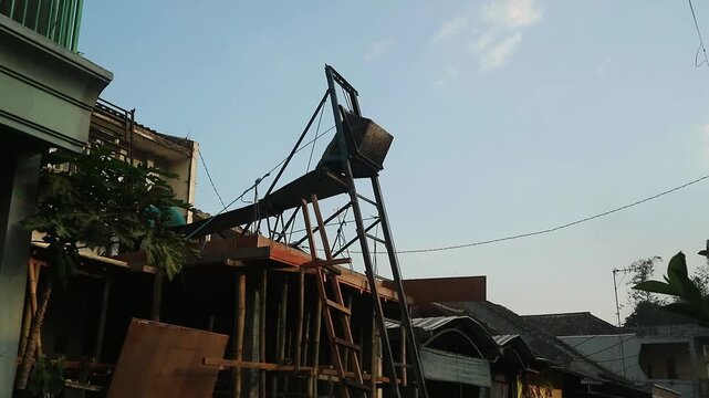 A metal construction hoist frame used for lifting building materials at a residential site.