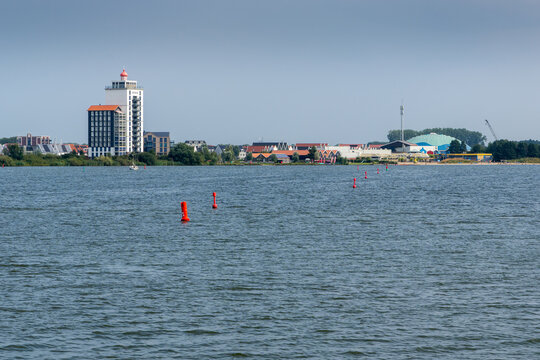 View from Lake Wolderwijd toward the Harderwijk skyline, featuring the landmark &ldquo;Vuurtoren&rdquo; building and the Dolfinarium marine park.