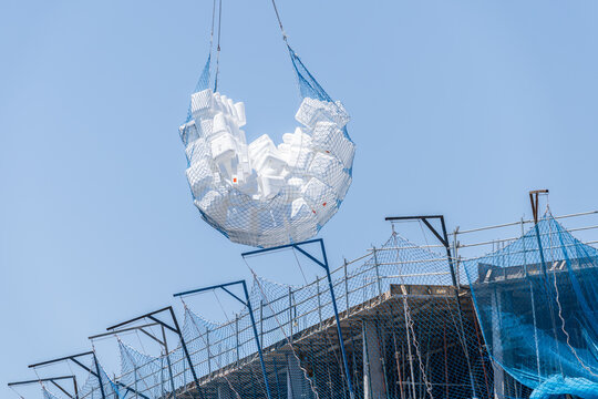 Construction debris chute with netting against blue sky
