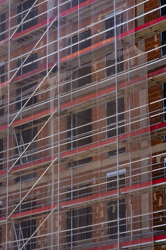 Scaffolding and safety net on unfinished brick facade