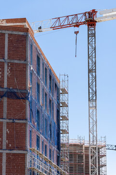 Tower crane above brick building under construction