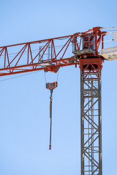 Tower crane boom and hook against clear blue sky