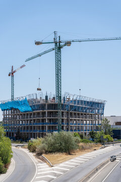 Tower crane above unfinished concrete building at construction site