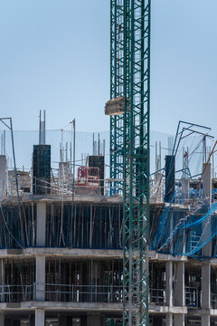 Tower crane at concrete building construction site