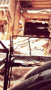 This location features rusted machinery and old buildings that show signs of neglect. Weeds grow through cracks, highlighting the passage of time in this abandoned space.