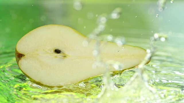 Super Slow Motion Shot of Fresh Pear Falling into Water and Making Splash at 1000fps.