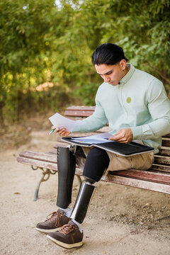 Latino man with prosthetic legs working in park