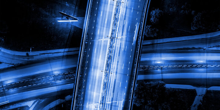 Futuristic blue highway aerial, night traffic motion, urban flyover