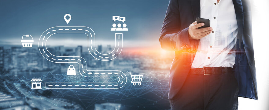 A businessman in a suit holds a smartphone with a dynamic urban backdrop, featuring illustrative icons that symbolize digital transformation and the customer journey for business success. Ledger