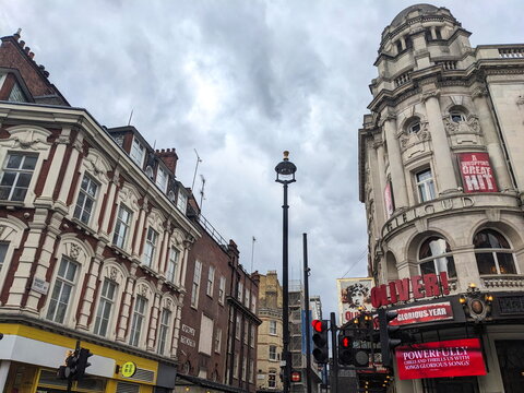 Apollo Theatre and Gielgud Theatre on Shaftesbury Avenue under a cloudy sky in London West End