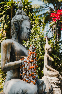 Buddha statue with flower garland at Buddha Park in Vientiane