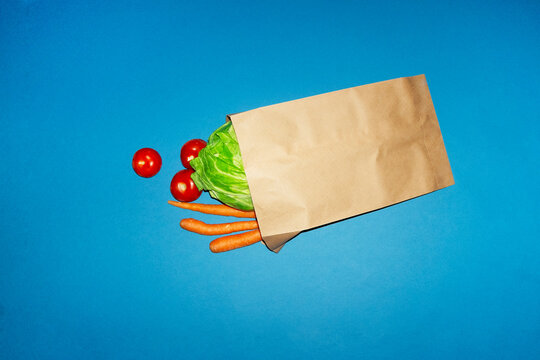 Fresh vegetable grocery bag on blue background